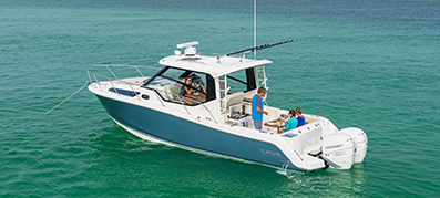 A blue and white Boston Whaler boat sits anchored in the water