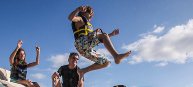 Kid jumping into tube from boat