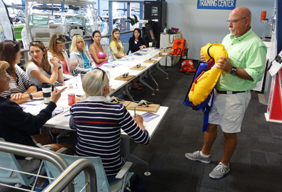 man holding life jacket in front of a group of women sitting at a table