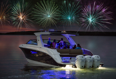 a boat with people on board in open water looking at fireworks at night
