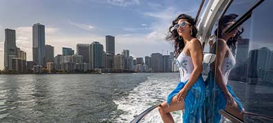 Lady standing on side of the boat with Miami background